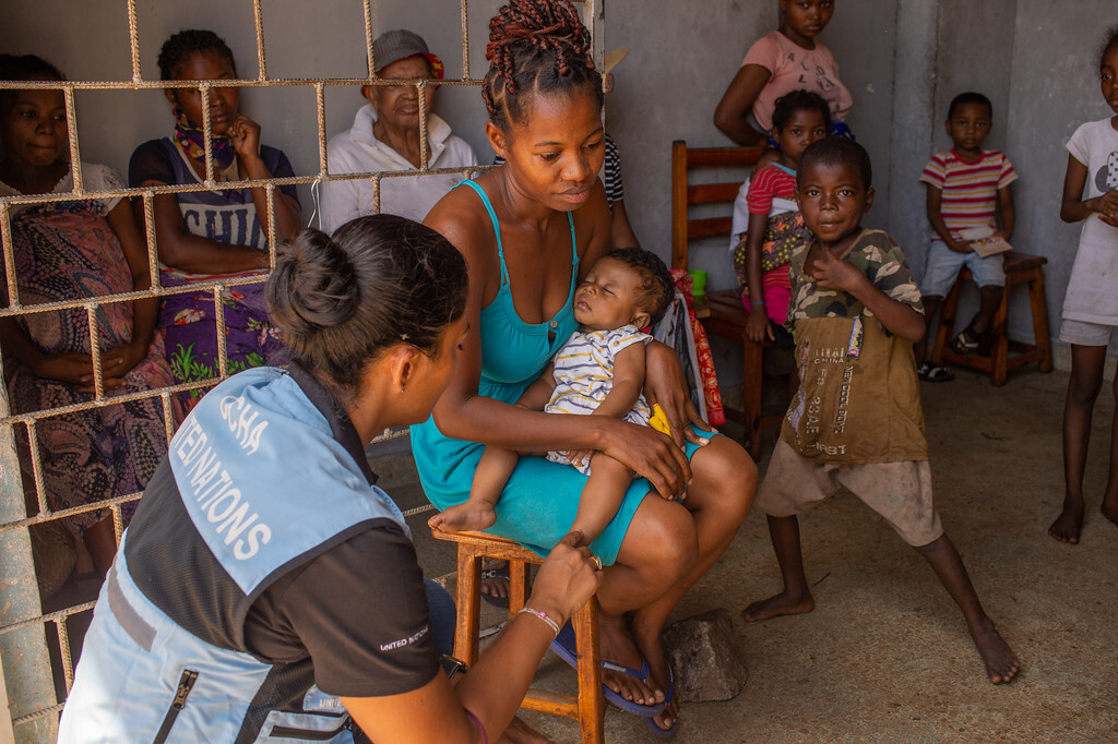 UNDAC member speaking to a mother and her newborn after the cyclone in Madagascar, 2022.