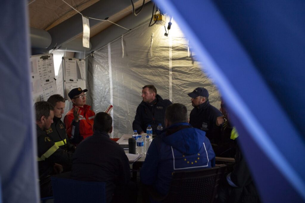 UNDAC and USAR members meeting in a tent in Hatay, Türkiye, 2023.