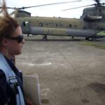 UNDAC member in front of a military helicopter.