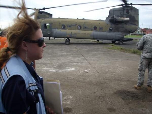 UNDAC member in front of a military helicopter.