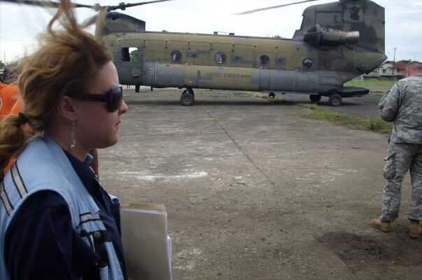 UNDAC member in front of a military helicopter.