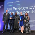 UNDAC and INSARAG Focal Points in front of screen, holding the UN Heroes Award